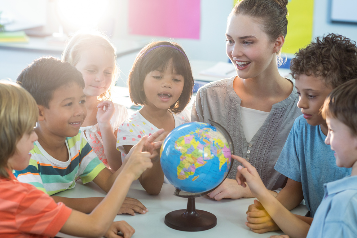 Female teacher showing globe to children